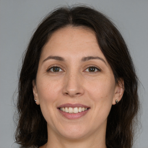 Joyful white adult female with medium  brown hair and brown eyes