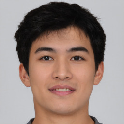 Joyful asian young-adult male with short  black hair and brown eyes