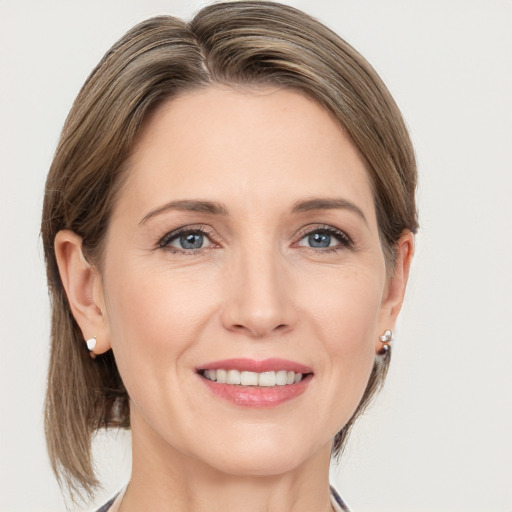 Joyful white adult female with medium  brown hair and grey eyes