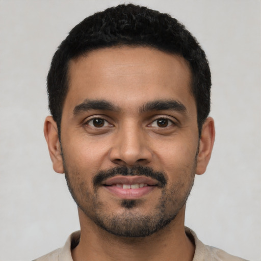 Joyful latino young-adult male with short  black hair and brown eyes