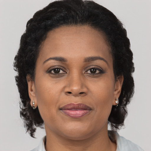 Joyful black adult female with medium  brown hair and brown eyes