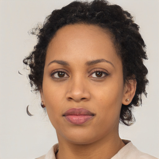 Joyful black young-adult female with short  black hair and brown eyes