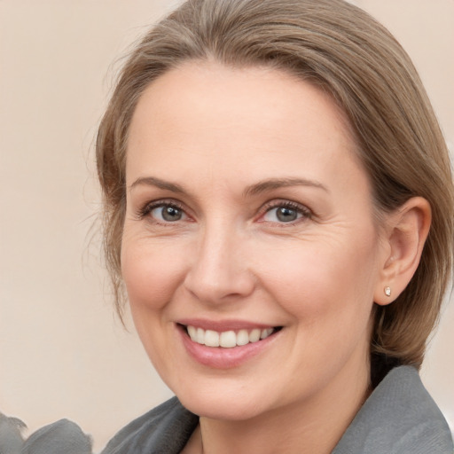 Joyful white adult female with medium  brown hair and brown eyes