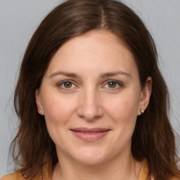 Joyful white adult female with long  brown hair and brown eyes