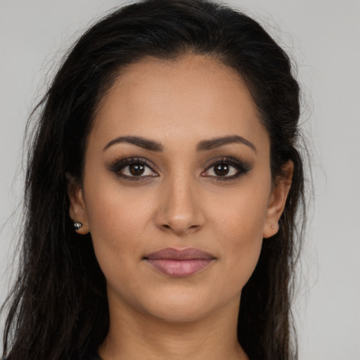 Joyful latino young-adult female with long  brown hair and brown eyes