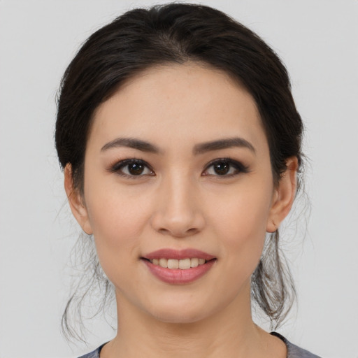 Joyful white young-adult female with medium  black hair and brown eyes