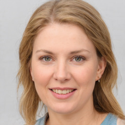 Joyful white young-adult female with medium  brown hair and blue eyes