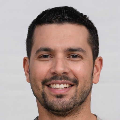 Joyful white young-adult male with short  black hair and brown eyes