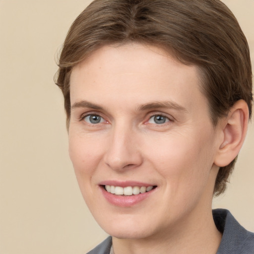 Joyful white young-adult female with short  brown hair and grey eyes