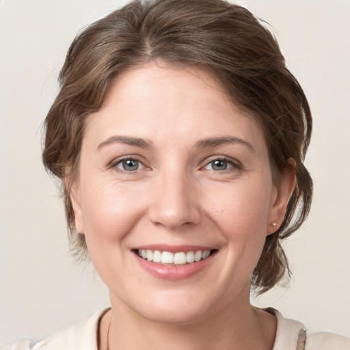 Joyful white young-adult female with medium  brown hair and grey eyes