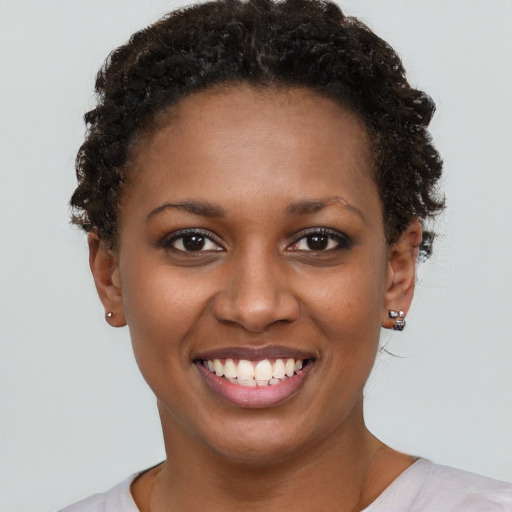 Joyful black young-adult female with short  brown hair and brown eyes