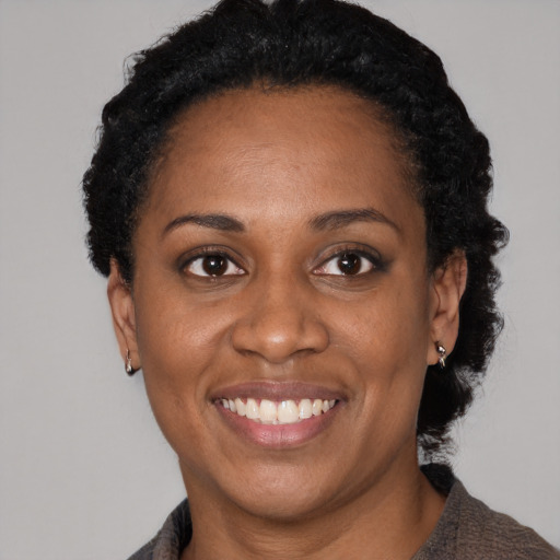 Joyful black adult female with short  black hair and brown eyes