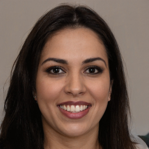 Joyful latino young-adult female with long  brown hair and brown eyes