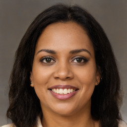 Joyful black young-adult female with long  brown hair and brown eyes