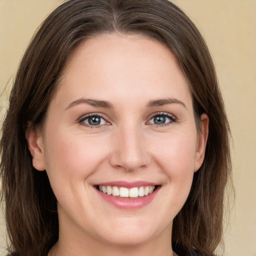 Joyful white young-adult female with long  brown hair and green eyes