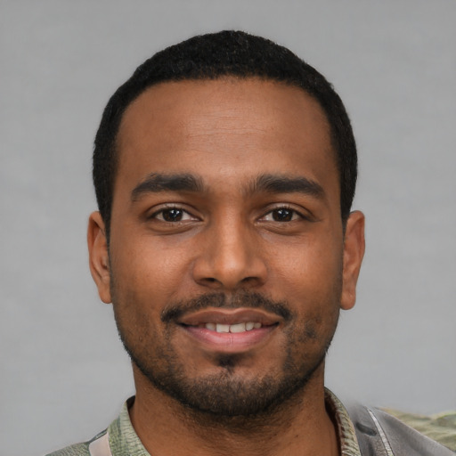 Joyful black young-adult male with short  black hair and brown eyes