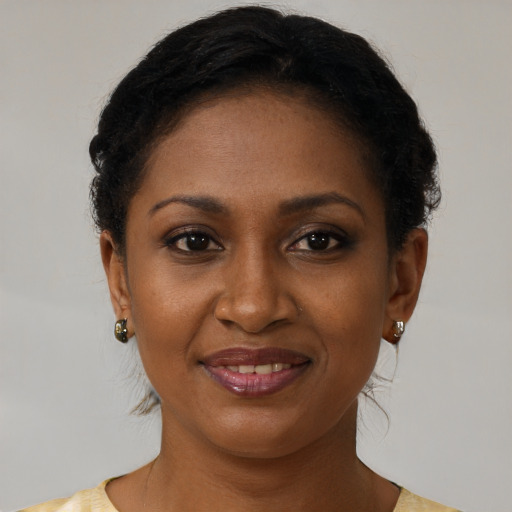 Joyful black young-adult female with short  brown hair and brown eyes