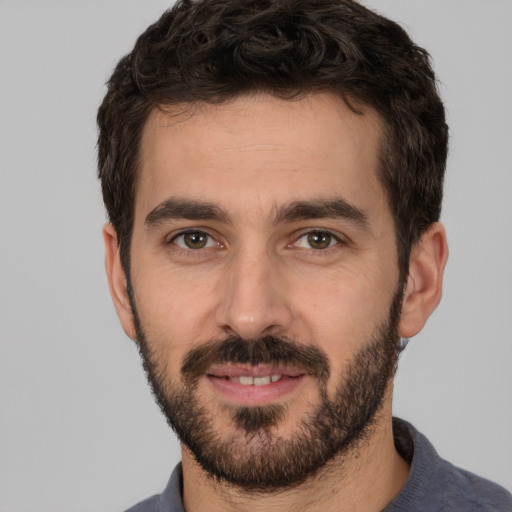 Joyful white young-adult male with short  black hair and brown eyes