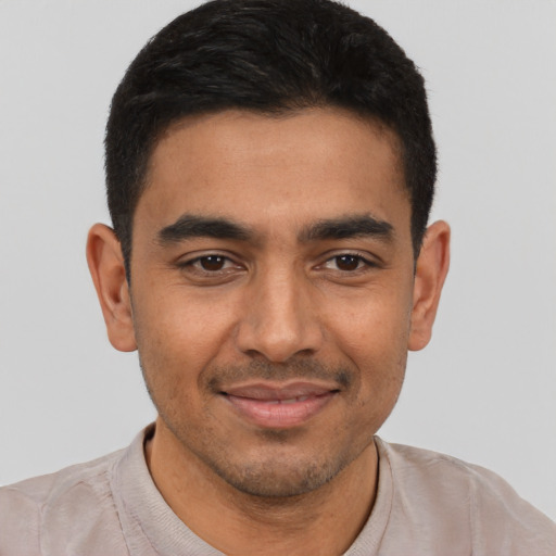 Joyful latino young-adult male with short  black hair and brown eyes