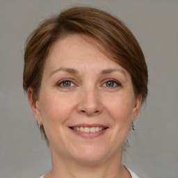 Joyful white adult female with medium  brown hair and grey eyes