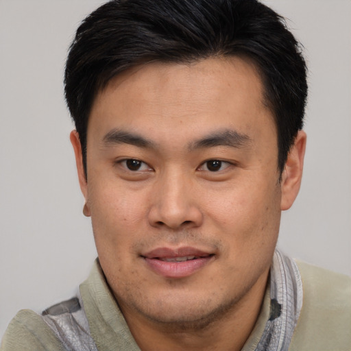 Joyful asian young-adult male with short  brown hair and brown eyes