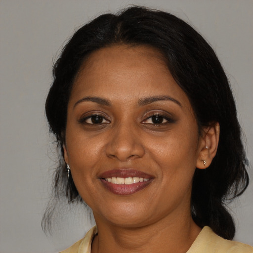 Joyful black young-adult female with medium  brown hair and brown eyes