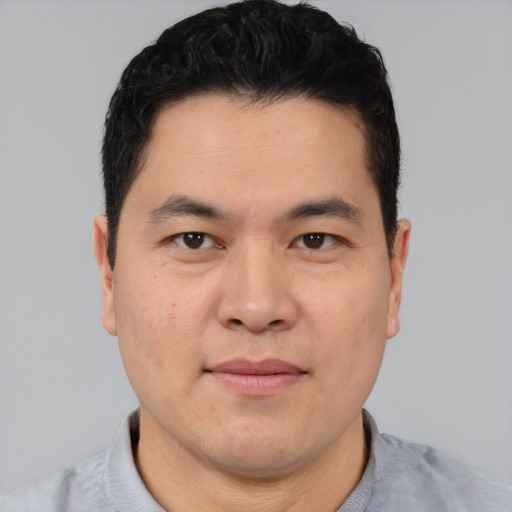 Joyful asian young-adult male with short  black hair and brown eyes