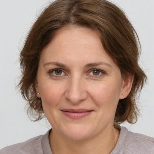 Joyful white adult female with medium  brown hair and grey eyes