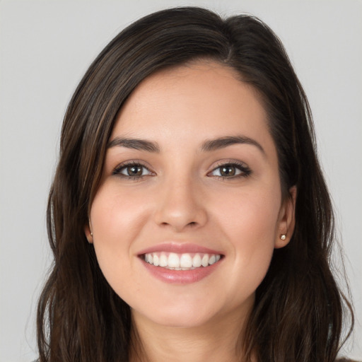 Joyful white young-adult female with long  brown hair and brown eyes