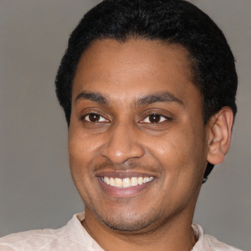 Joyful latino young-adult male with short  black hair and brown eyes