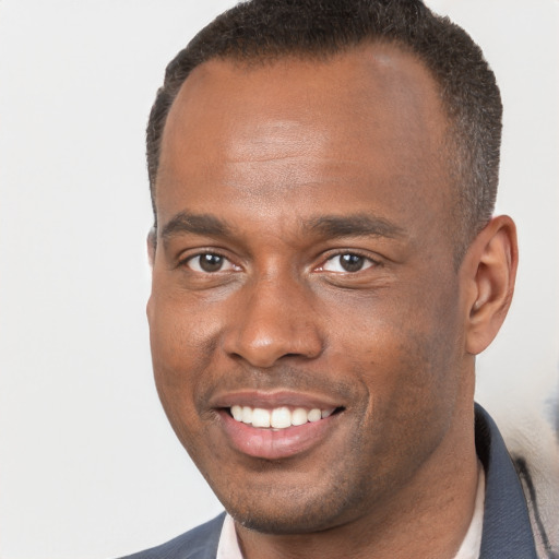 Joyful black young-adult male with short  brown hair and brown eyes