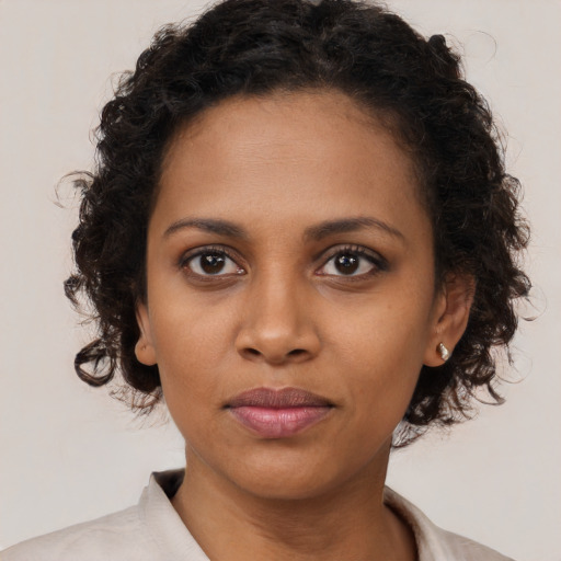 Joyful black young-adult female with medium  brown hair and brown eyes