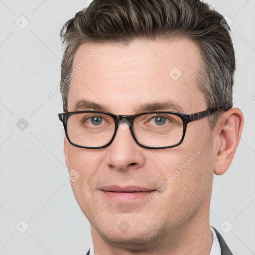 Joyful white adult male with short  brown hair and grey eyes