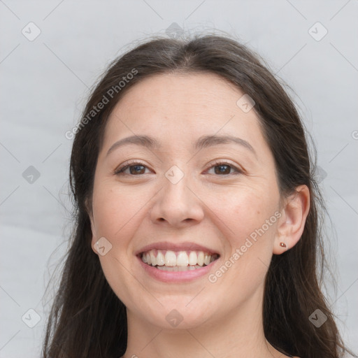 Joyful white adult female with long  brown hair and brown eyes