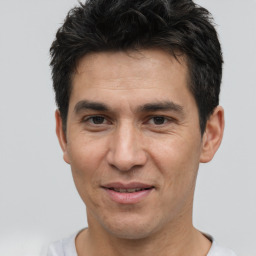 Joyful white adult male with short  black hair and brown eyes