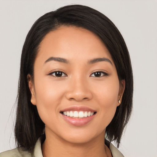 Joyful latino young-adult female with long  brown hair and brown eyes