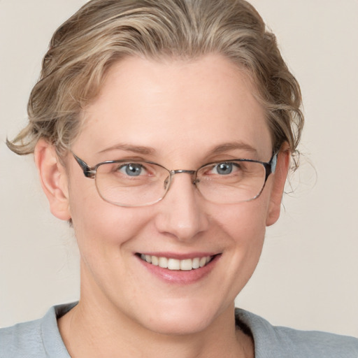 Joyful white adult female with medium  brown hair and blue eyes