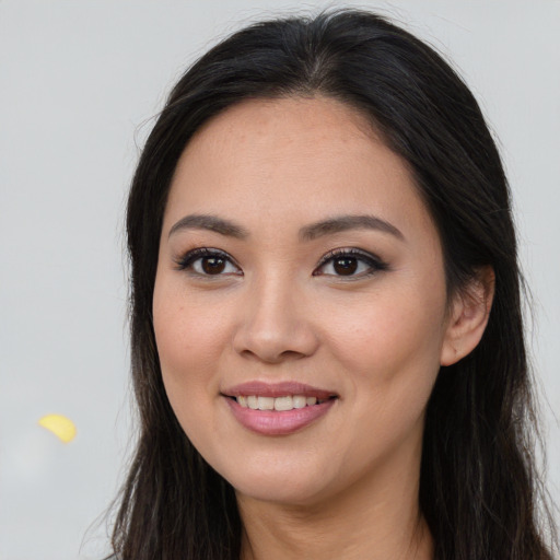 Joyful asian young-adult female with long  brown hair and brown eyes