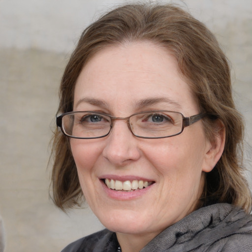 Joyful white adult female with medium  brown hair and blue eyes