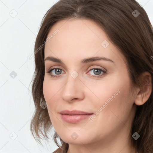 Joyful white young-adult female with long  brown hair and grey eyes