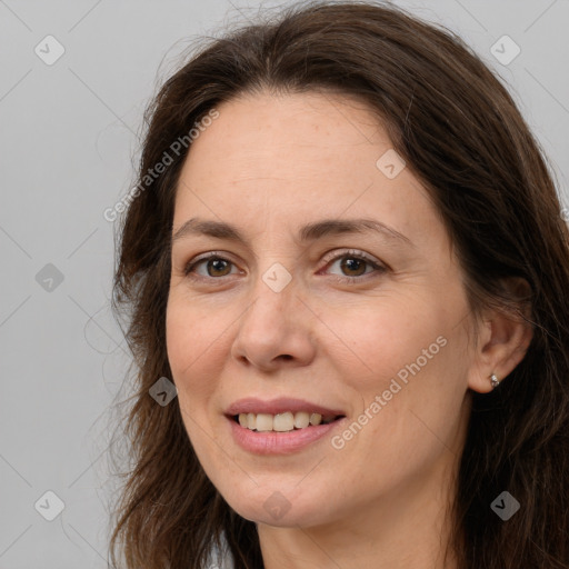 Joyful white adult female with long  brown hair and brown eyes