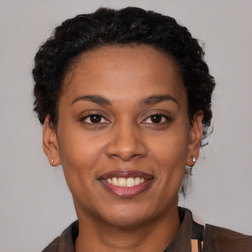 Joyful black young-adult female with short  brown hair and brown eyes