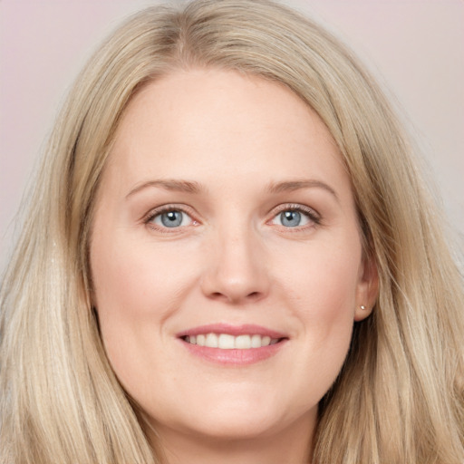 Joyful white young-adult female with long  brown hair and blue eyes