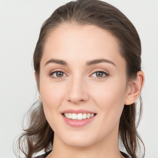 Joyful white young-adult female with medium  brown hair and grey eyes