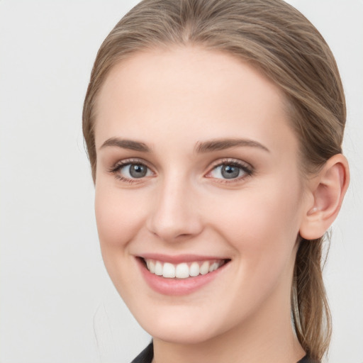 Joyful white young-adult female with long  brown hair and blue eyes