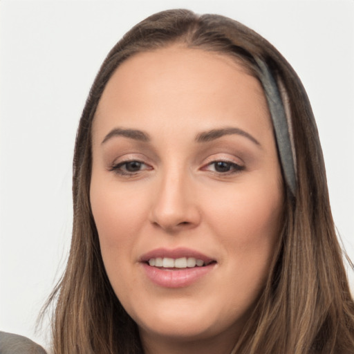 Joyful white young-adult female with long  brown hair and brown eyes