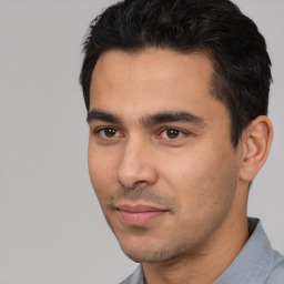 Joyful white young-adult male with short  black hair and brown eyes