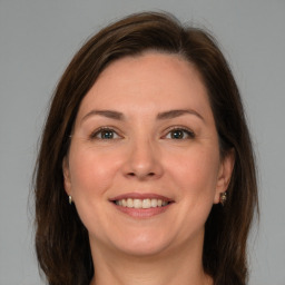 Joyful white adult female with long  brown hair and grey eyes