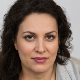 Joyful white adult female with long  brown hair and brown eyes