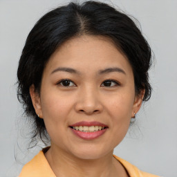 Joyful asian young-adult female with medium  brown hair and brown eyes